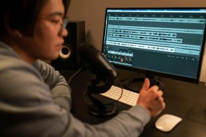 Featured image for a blog post on enhancing audio storytelling with sound and music. A sound designer edits audio to transform a podcast, using music and effects to create an immersive experience.