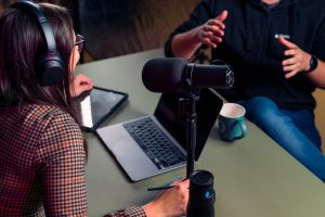 Podcast guest preparing for an interview with a microphone, laptop, and headphones—perfect setup for a successful podcast guest appearance.
